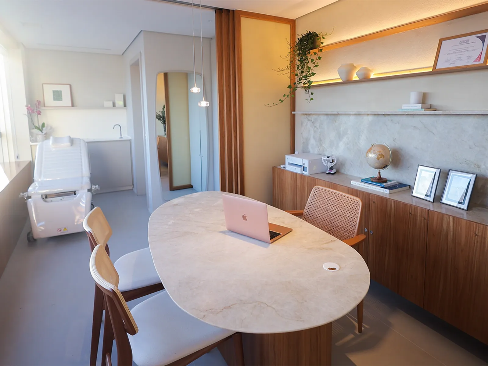 Sala de atendimento da Uroflow, com mesa oval de madeira clara.